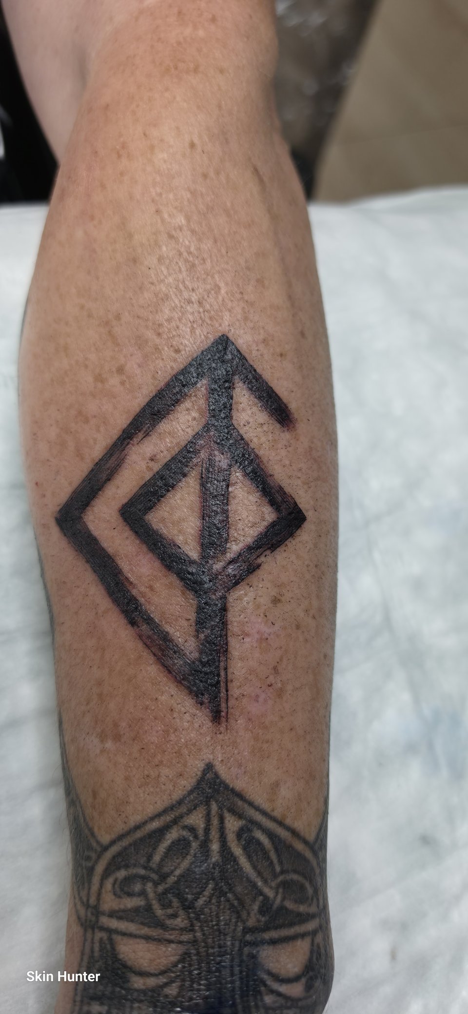 Blackwork-Rune aus kräftigen schwarzen Linien am Unterarm