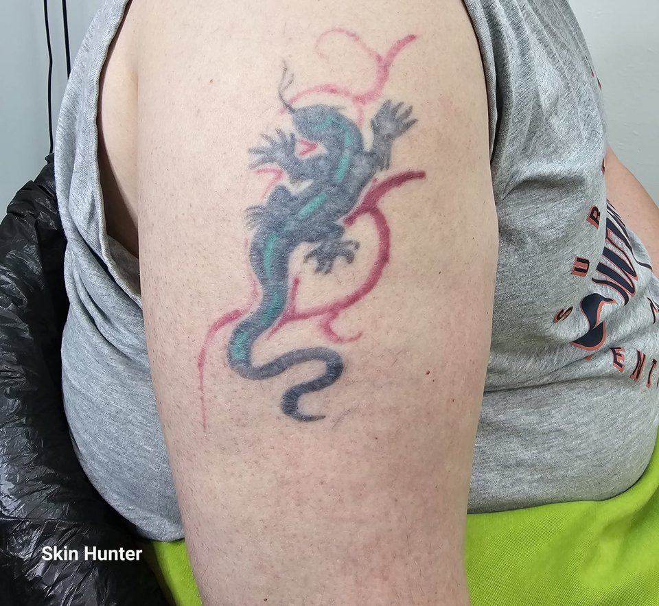 Vorher: altes farbiges Eidechsen-Tattoo am Oberarm