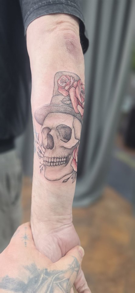 Totenkopf mit Hut und roten Rosen am Unterarm