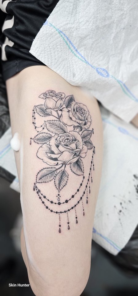 Rose mit Ornament und Perlenkette am Oberschenkel