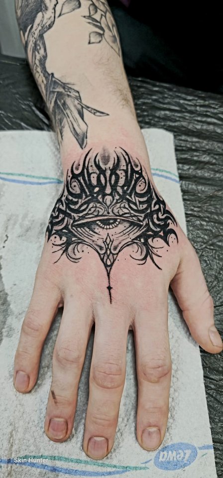 Ornamentales Tattoo auf dem Handrücken in Schwarz