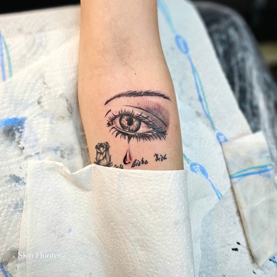 Realistisches Auge in Schwarz-Grau am Unterarm
