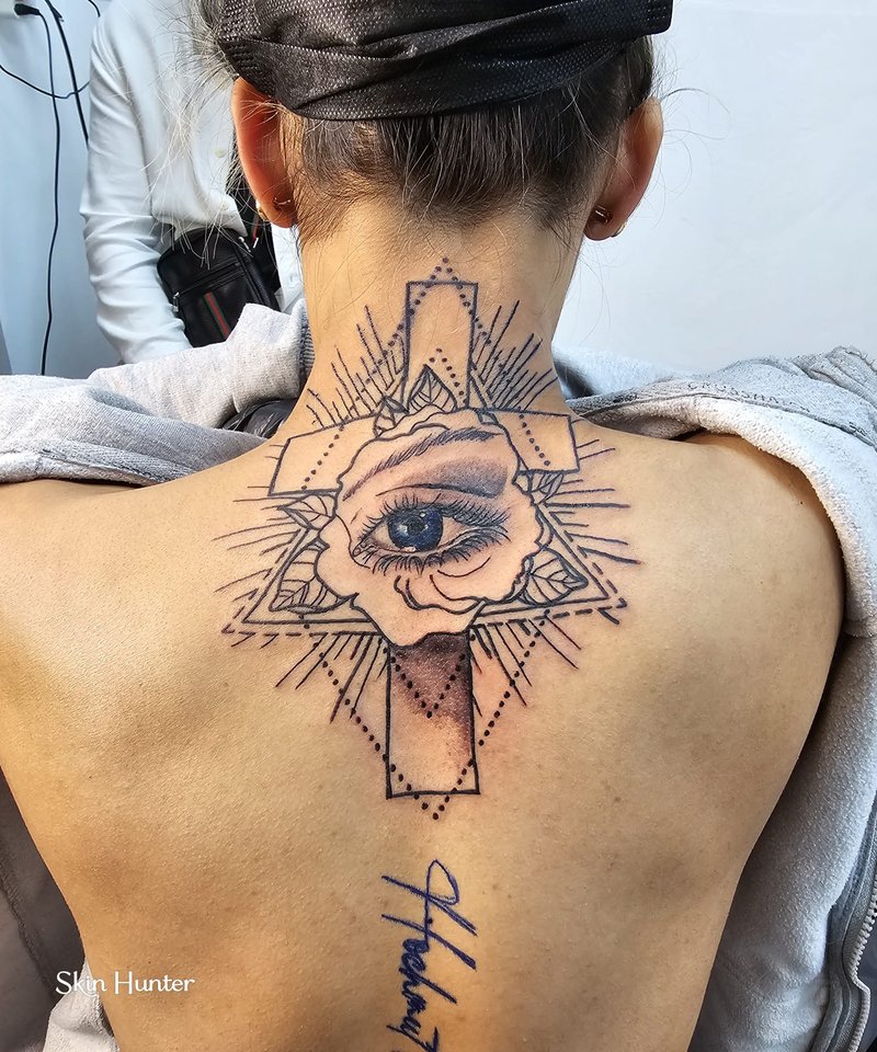 Auge im Dreieck mit Kreuz und Schriftzug am oberen Rücken