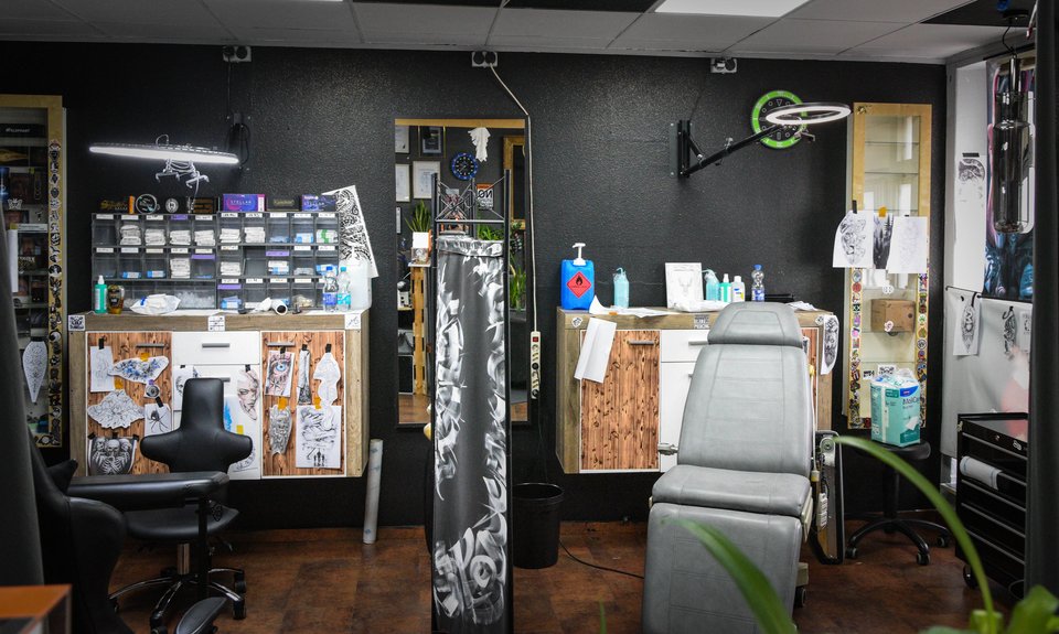 Tattoo-Arbeitsplatz mit Liege, Hocker und Material im Studio