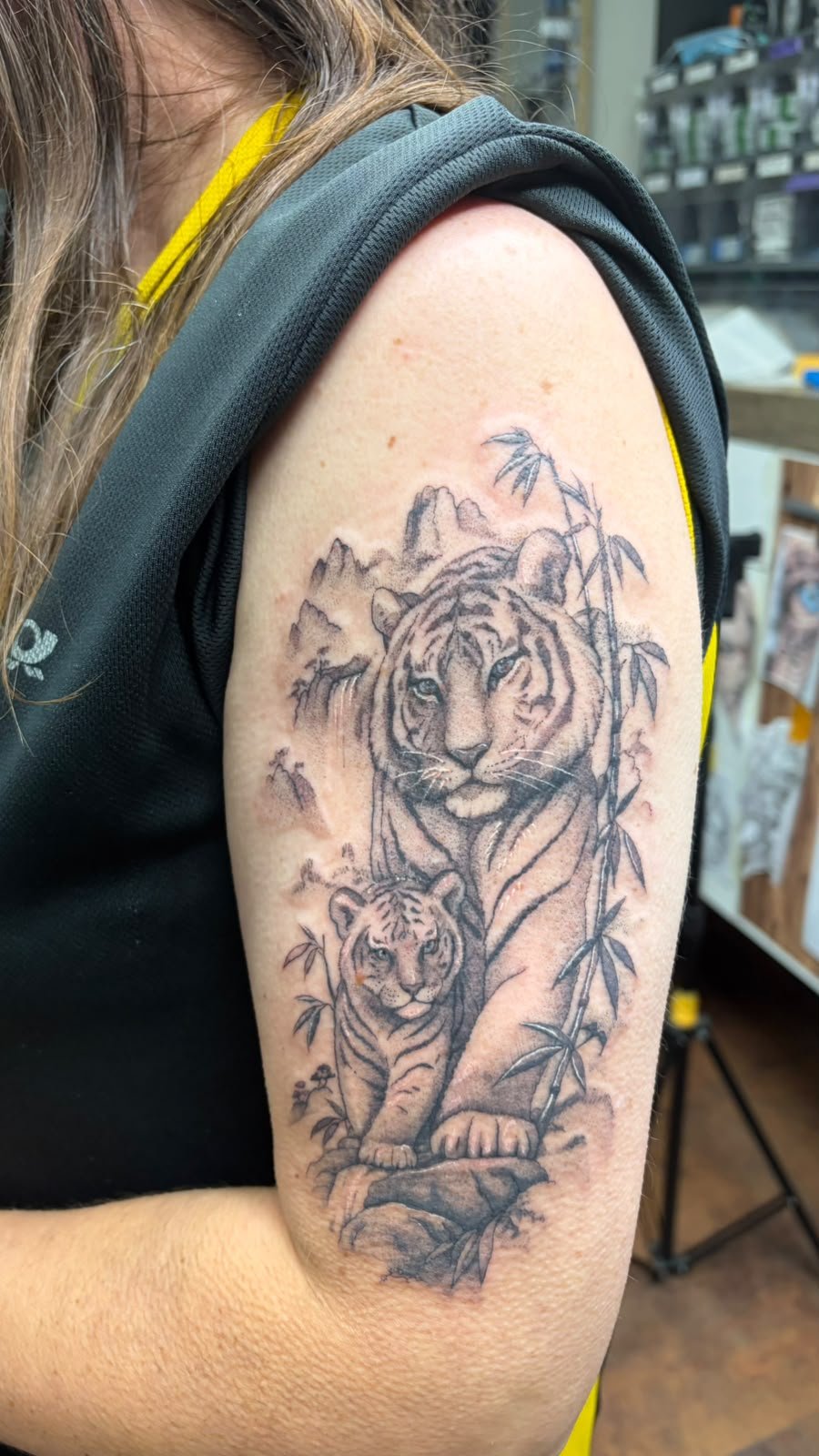 Tigermutter mit Jungtier und Bambus als Tierportrait am Oberarm